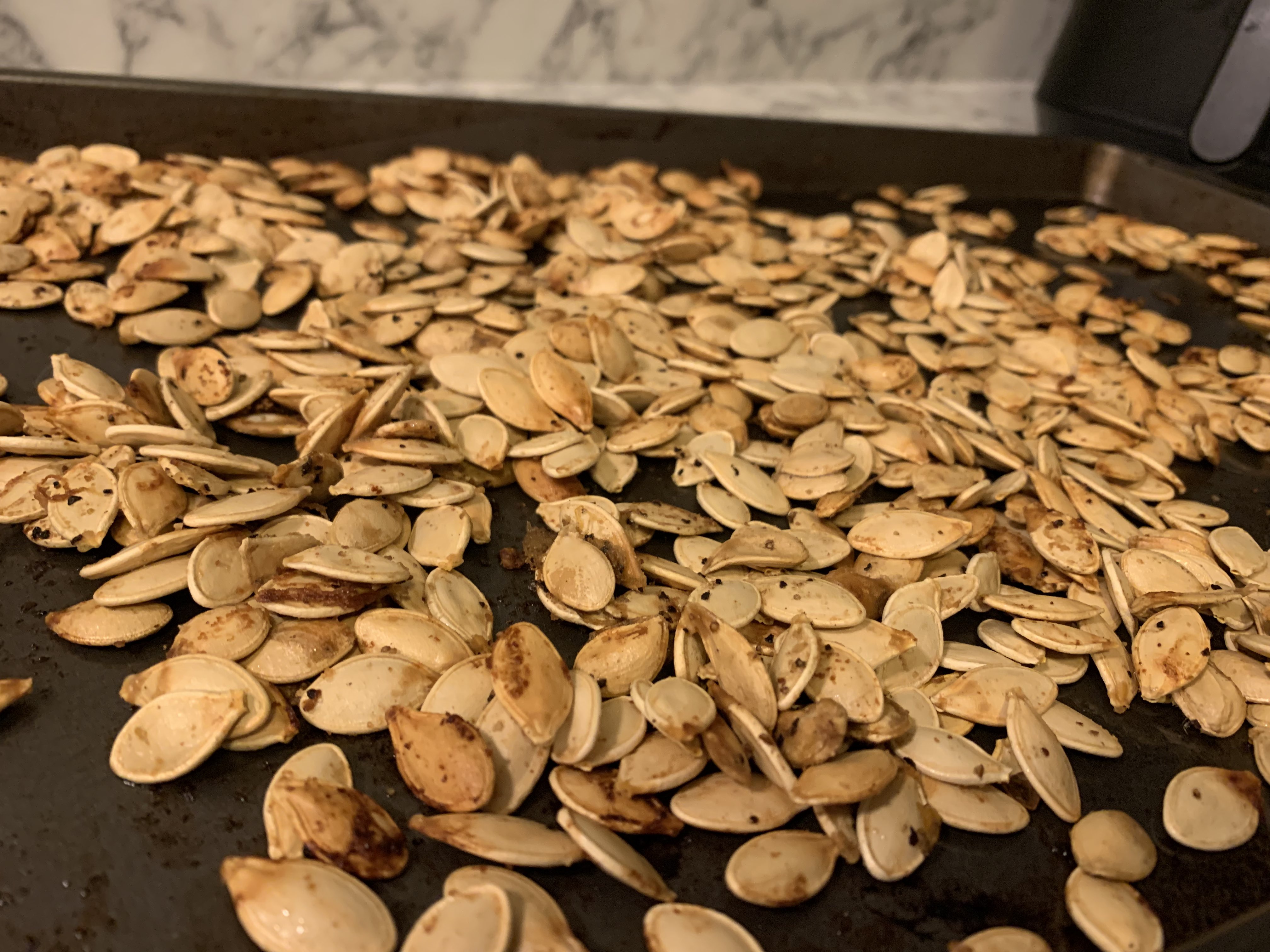 A tray of seasoned, roasted pumpkin seeds